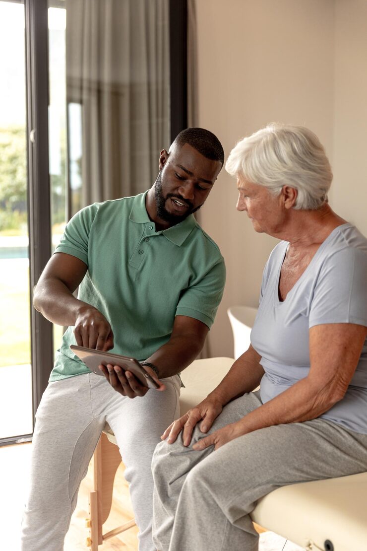 Home african american male physiotherapist showing digital tablet caucasian senior woman home 13339 334974